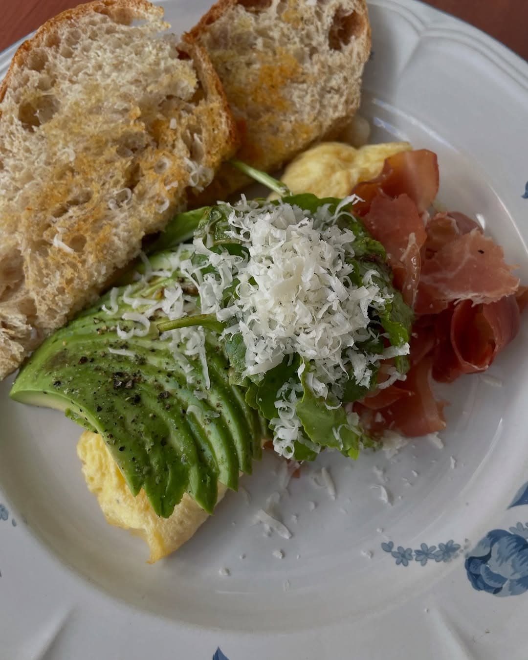 Tosta de aguacate, huevo y jamón serrano con queso rallado
